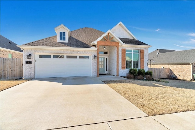 view of front facade with brick siding, concrete driveway, a garage, and fence