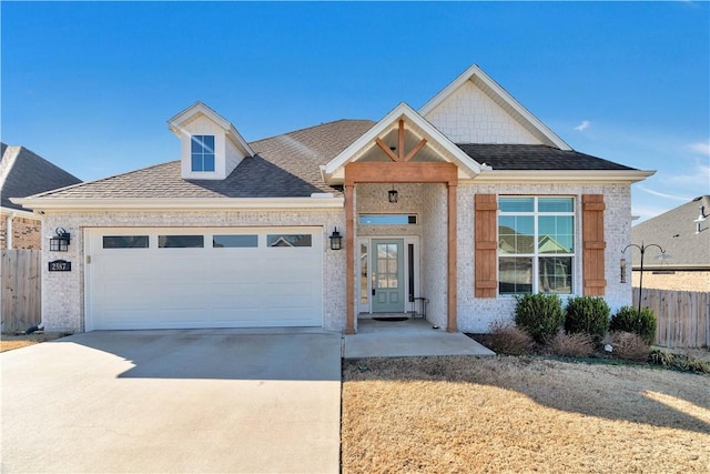 view of front of home with brick siding, fence, concrete driveway, roof with shingles, and an attached garage