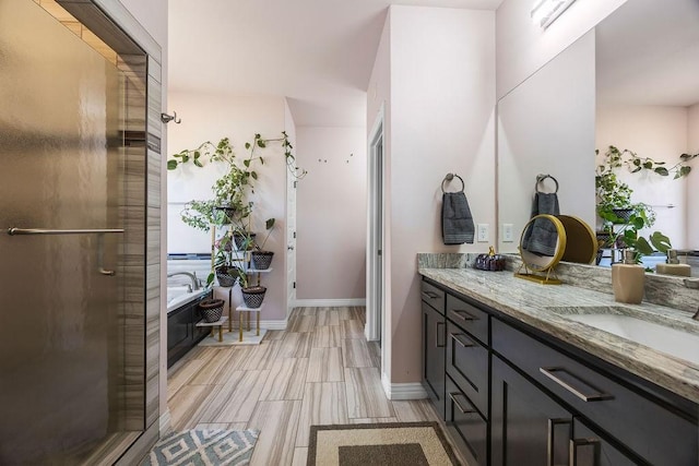 full bathroom with an enclosed shower, wood finished floors, baseboards, a bath, and vanity