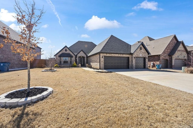 french country home featuring a front lawn, driveway, fence, an attached garage, and brick siding