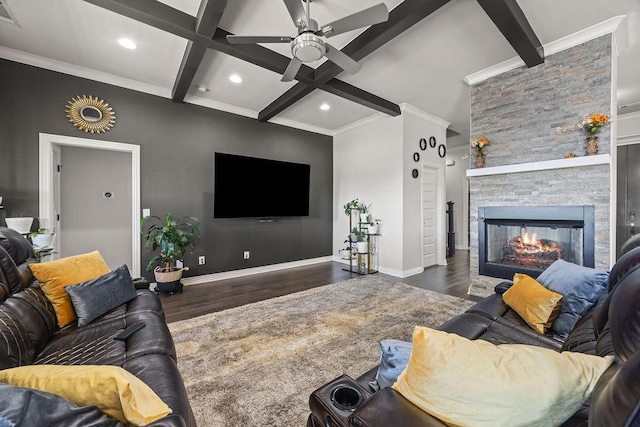 living room featuring beamed ceiling, coffered ceiling, wood finished floors, a stone fireplace, and baseboards