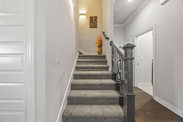 staircase featuring baseboards, wood finished floors, and ornamental molding