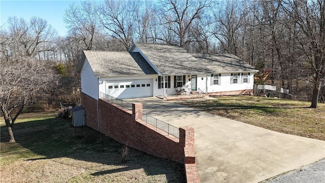 view of front of property with a front lawn, a garage, driveway, and roof with shingles