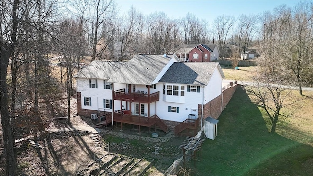 back of house featuring a lawn, stairs, a balcony, and fence