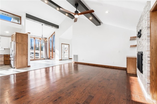 unfurnished living room featuring light wood-type flooring, visible vents, high vaulted ceiling, beamed ceiling, and a stone fireplace