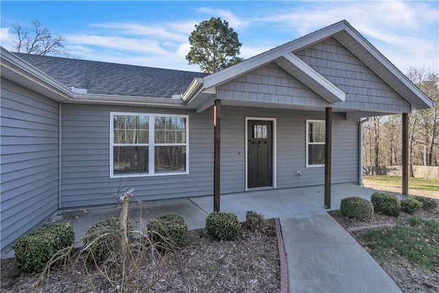 view of front of home featuring covered porch and roof with shingles