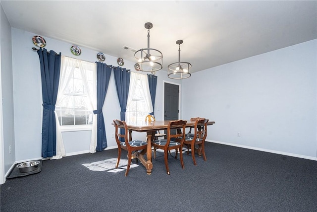 carpeted dining area featuring visible vents, baseboards, and a chandelier