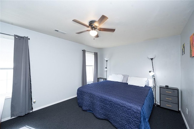 bedroom featuring baseboards, visible vents, dark colored carpet, and ceiling fan