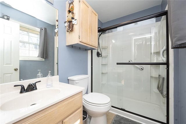 full bath with tile patterned floors, toilet, a stall shower, and vanity