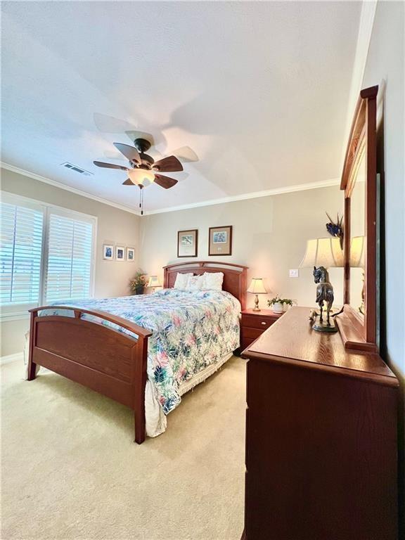 11 Saint Andrews Lane Holiday Island Unit 9, Holiday Island, AR 72631 - bedroom with light carpet, ornamental molding, and ceiling fan