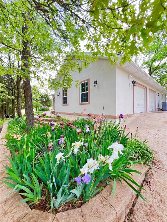 11 Saint Andrews Lane Holiday Island Unit 9, Holiday Island, AR 72631 - view of home's exterior with stucco siding, a garage, and driveway