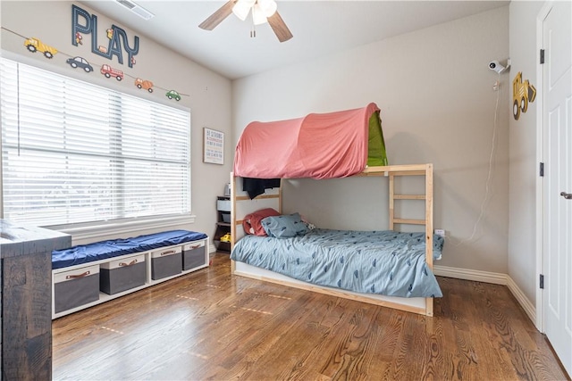 bedroom featuring visible vents, baseboards, wood finished floors, and a ceiling fan