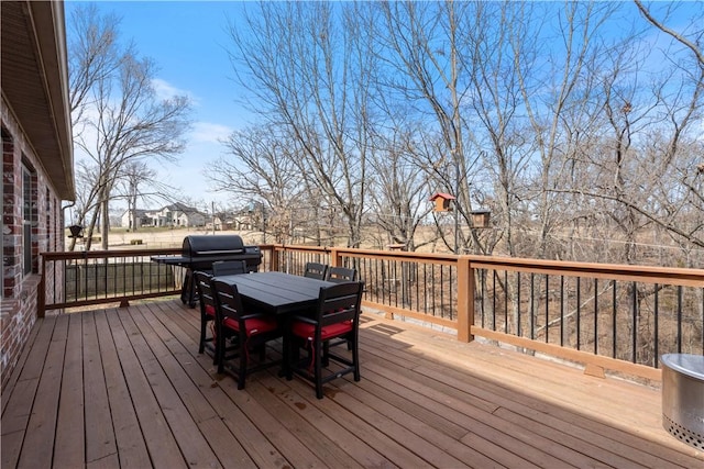 wooden terrace with outdoor dining space and grilling area