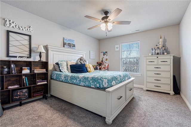 bedroom with visible vents, baseboards, ceiling fan, a textured ceiling, and light colored carpet