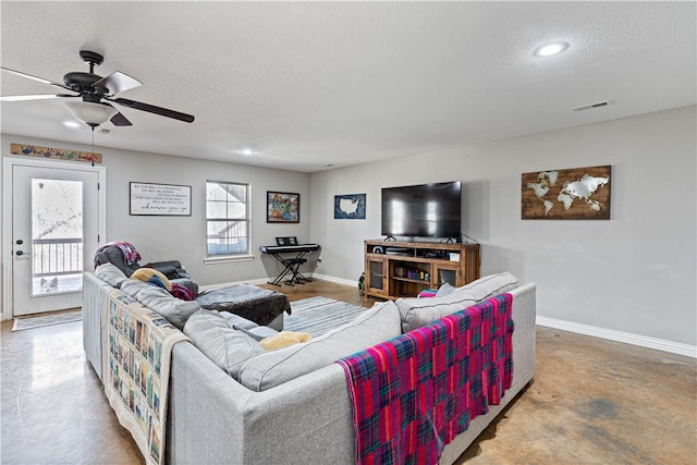 living area with visible vents, baseboards, concrete flooring, a textured ceiling, and a ceiling fan