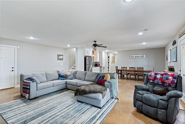 living room with recessed lighting, visible vents, a textured ceiling, and stairs