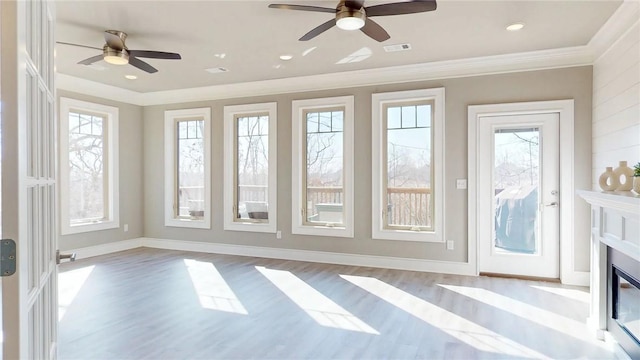 interior space featuring visible vents, a glass covered fireplace, and a ceiling fan