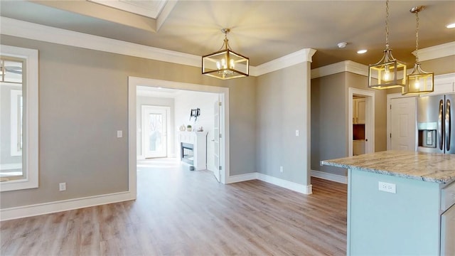 kitchen with baseboards, a fireplace, ornamental molding, light wood-style floors, and stainless steel fridge