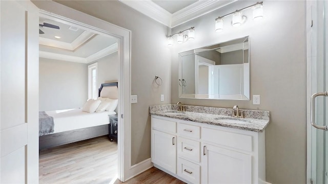 full bath with a sink, wood finished floors, ensuite bathroom, and crown molding