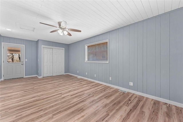 unfurnished bedroom with visible vents, baseboards, attic access, light wood-style floors, and a closet