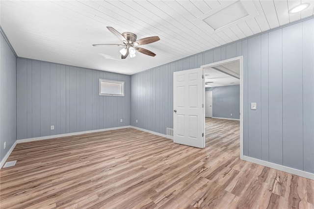 unfurnished room featuring light wood-type flooring, visible vents, baseboards, attic access, and ceiling fan