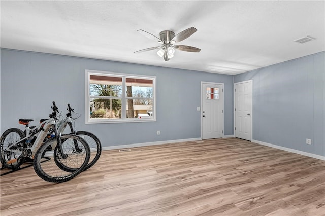 foyer featuring visible vents, baseboards, light wood-style floors, and ceiling fan