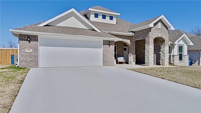 view of front facade featuring brick siding, fence, concrete driveway, roof with shingles, and an attached garage