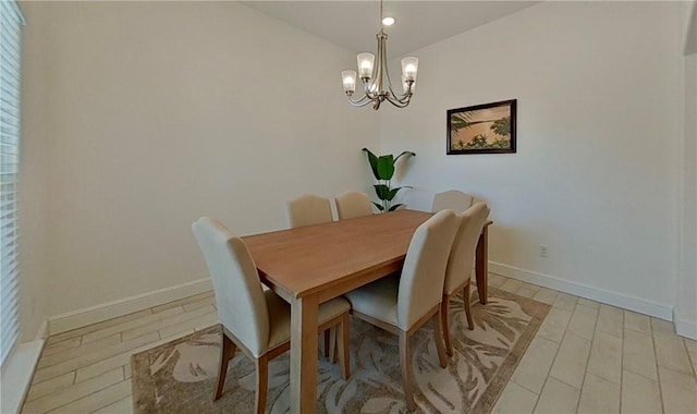 dining area with a notable chandelier, baseboards, and light wood-style floors