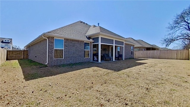 rear view of house with a patio, brick siding, and a fenced backyard