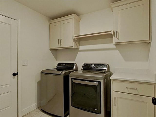 clothes washing area featuring baseboards, cabinet space, and independent washer and dryer