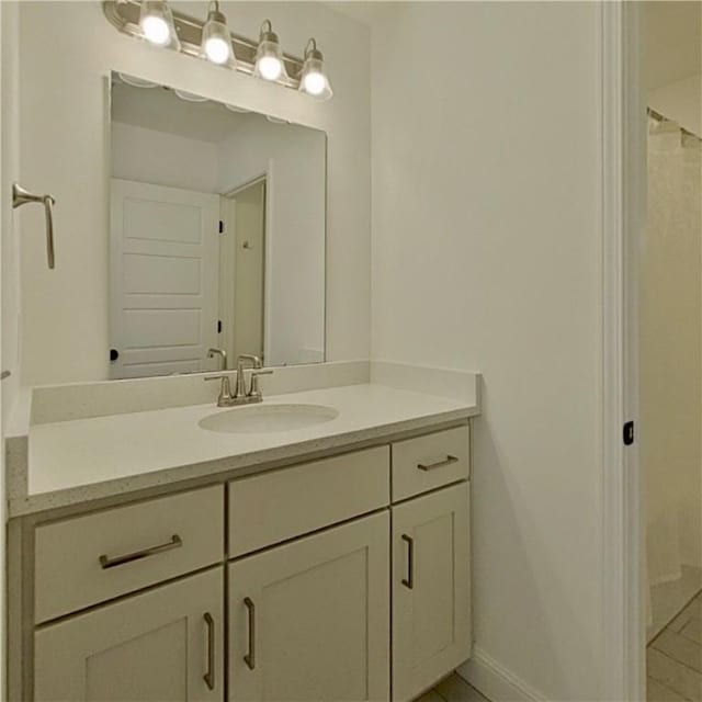 bathroom with vanity, baseboards, and tile patterned flooring