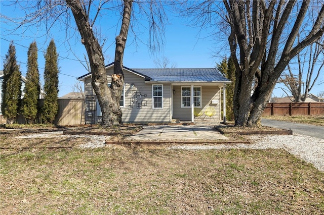 view of front of property with metal roof and fence