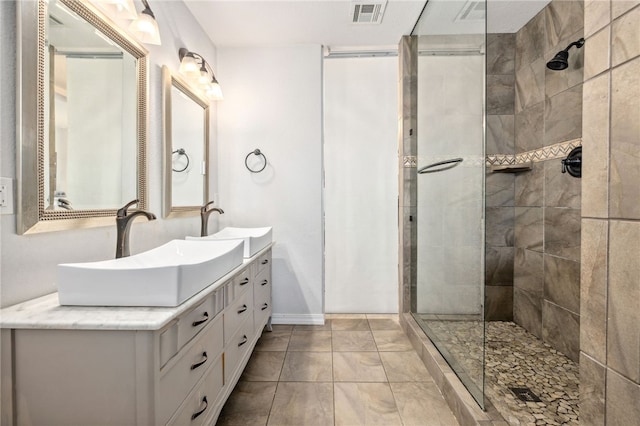 706 NW B St, Bentonville, AR 72712 - bathroom featuring a sink, double vanity, tiled shower, and visible vents