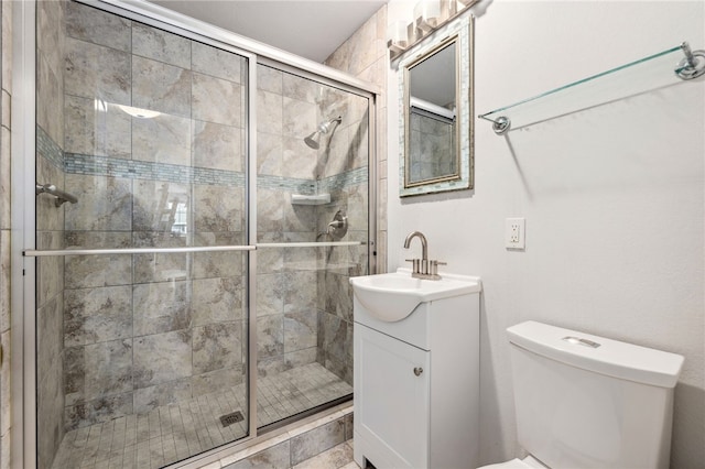 bathroom featuring a stall shower, toilet, and vanity