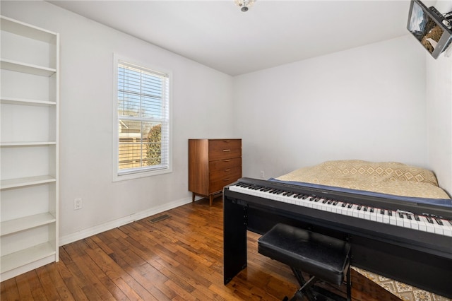 bedroom featuring hardwood / wood-style flooring, visible vents, and baseboards