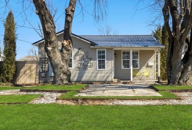 706 NW B St, Bentonville, AR 72712 - back of property with a patio area, a yard, and metal roof