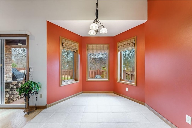 interior space featuring light tile patterned floors, baseboards, and a chandelier