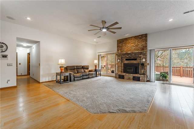 unfurnished living room featuring wood finished floors, baseboards, visible vents, ceiling fan, and a textured ceiling