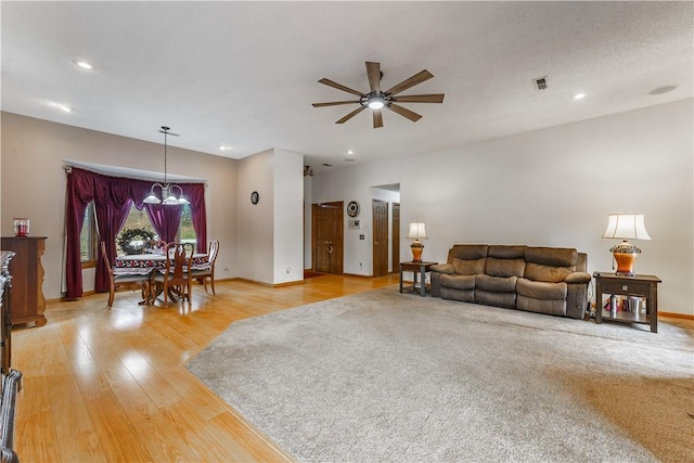 living room featuring a ceiling fan, baseboards, visible vents, recessed lighting, and light wood-type flooring