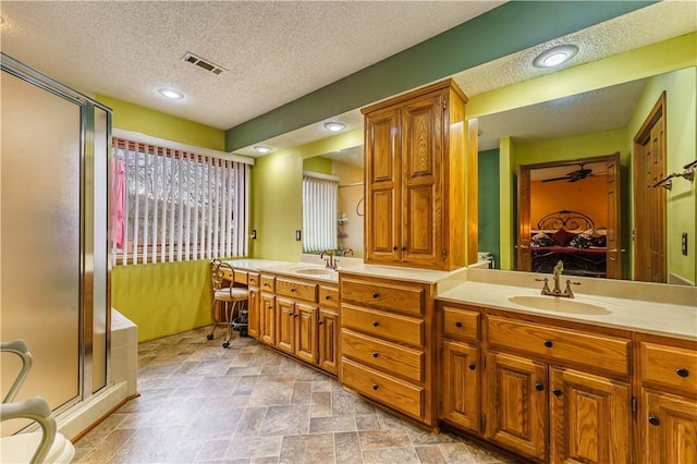 ensuite bathroom with visible vents, a shower stall, ensuite bathroom, and a sink