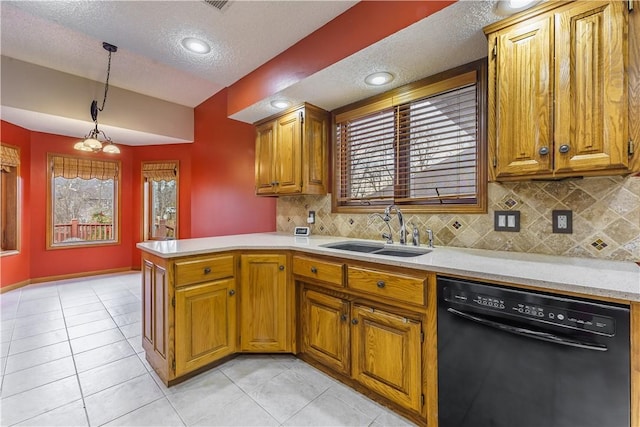 kitchen featuring light countertops, black dishwasher, a peninsula, brown cabinetry, and a sink