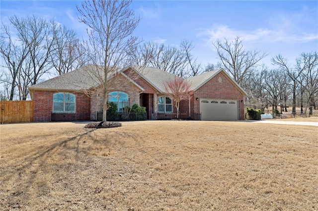 single story home with brick siding, an attached garage, and fence