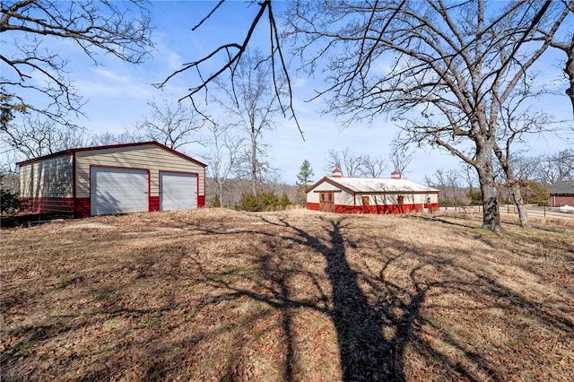 view of yard featuring a detached garage and an outbuilding