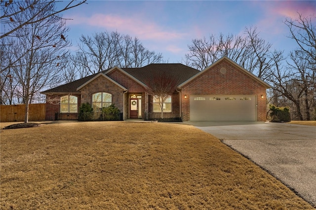 ranch-style house with fence, an attached garage, a yard, concrete driveway, and brick siding