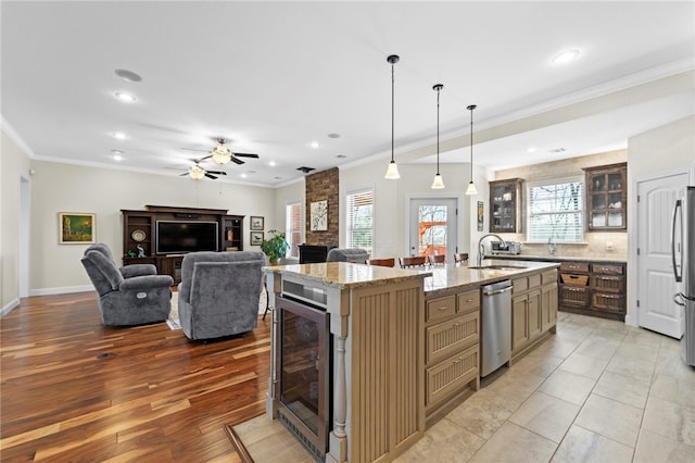 kitchen with beverage cooler, a fireplace, a sink, ornamental molding, and stainless steel appliances