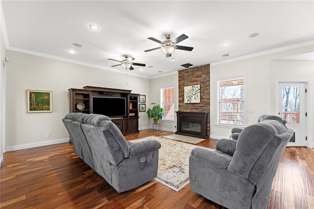 living room with baseboards, a stone fireplace, dark wood-style flooring, and crown molding