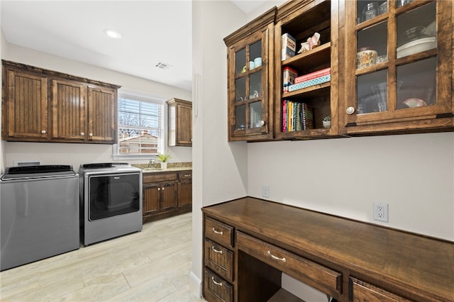 washroom featuring visible vents, cabinet space, recessed lighting, a sink, and washing machine and dryer