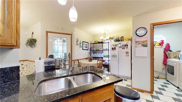 kitchen featuring light floors, separate washer and dryer, a sink, white refrigerator with ice dispenser, and a textured ceiling