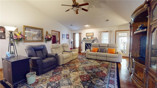 living room featuring visible vents, wood finished floors, a ceiling fan, and vaulted ceiling