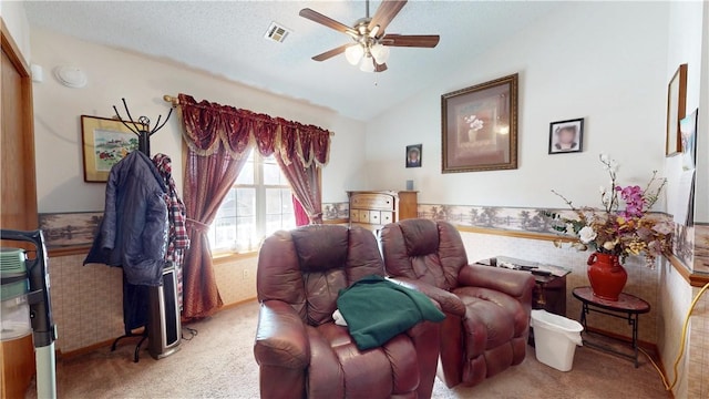 sitting room with a ceiling fan, carpet, visible vents, vaulted ceiling, and a textured ceiling